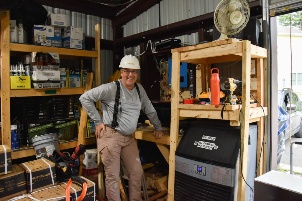Dmitry stands by the new ice machine powered entirely by a solar panel setup he designed and installed